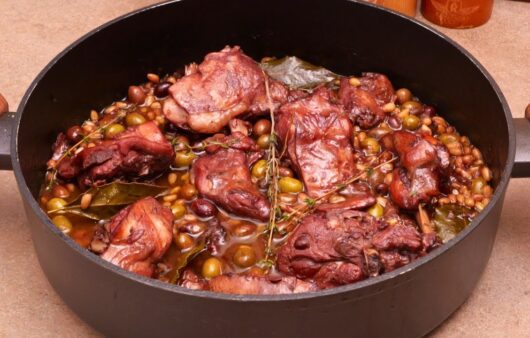 Coniglio alla ligure: una ricetta tradizionale profumata di olive taggiasche, pinoli ed erbe mediterranee. Un secondo piatto elegante e ricco di sapore, perfetto per ogni occasione.