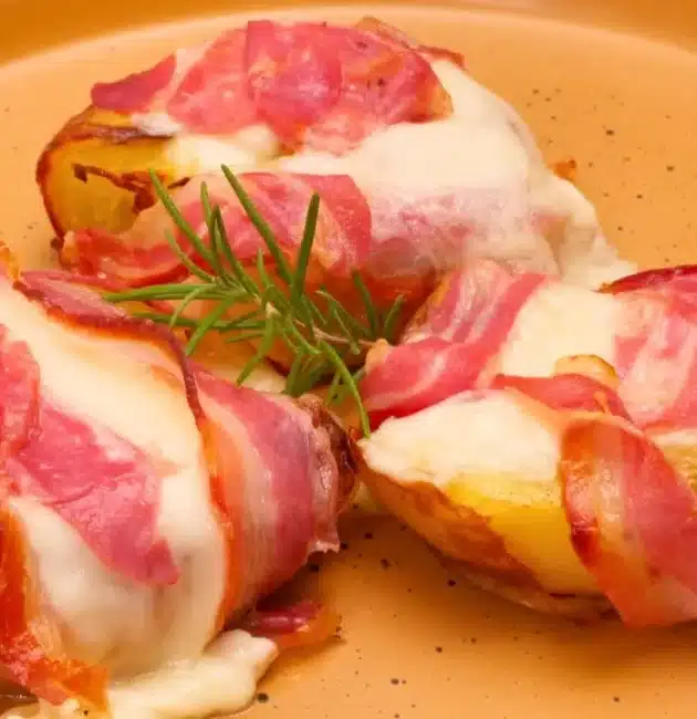 Le patate al forno filanti con pancetta sono un contorno ricco e irresistibile, capace di trasformarsi facilmente in un vero e proprio piatto unico. Dorate fuori, morbide dentro e arricchite da un cuore filante di formaggio e dalla sapidità della pancetta, rappresentano una di quelle ricette che conquistano al primo assaggio e mettono tutti d’accordo a tavola.