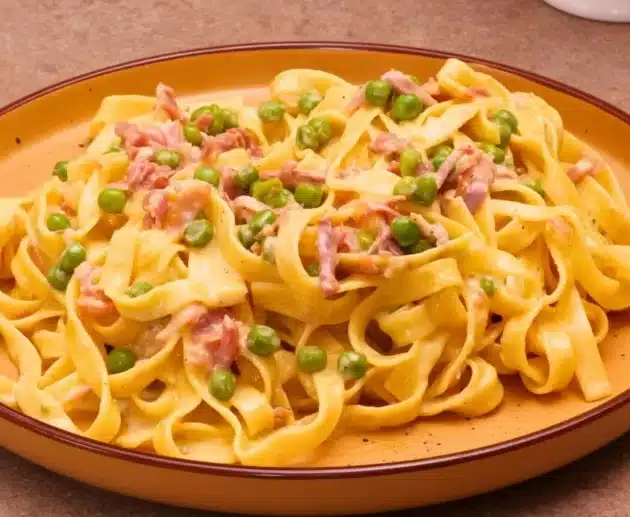 Come preparare le fettuccine alla papalina a modo mio: ricetta cremosa con uova, prosciutto, piselli e formaggi.