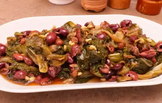 Come preparare la scarola alla napoletana: ricetta tradizionale con olive Itrane, capperi, acciughe, uvetta e pinoli.