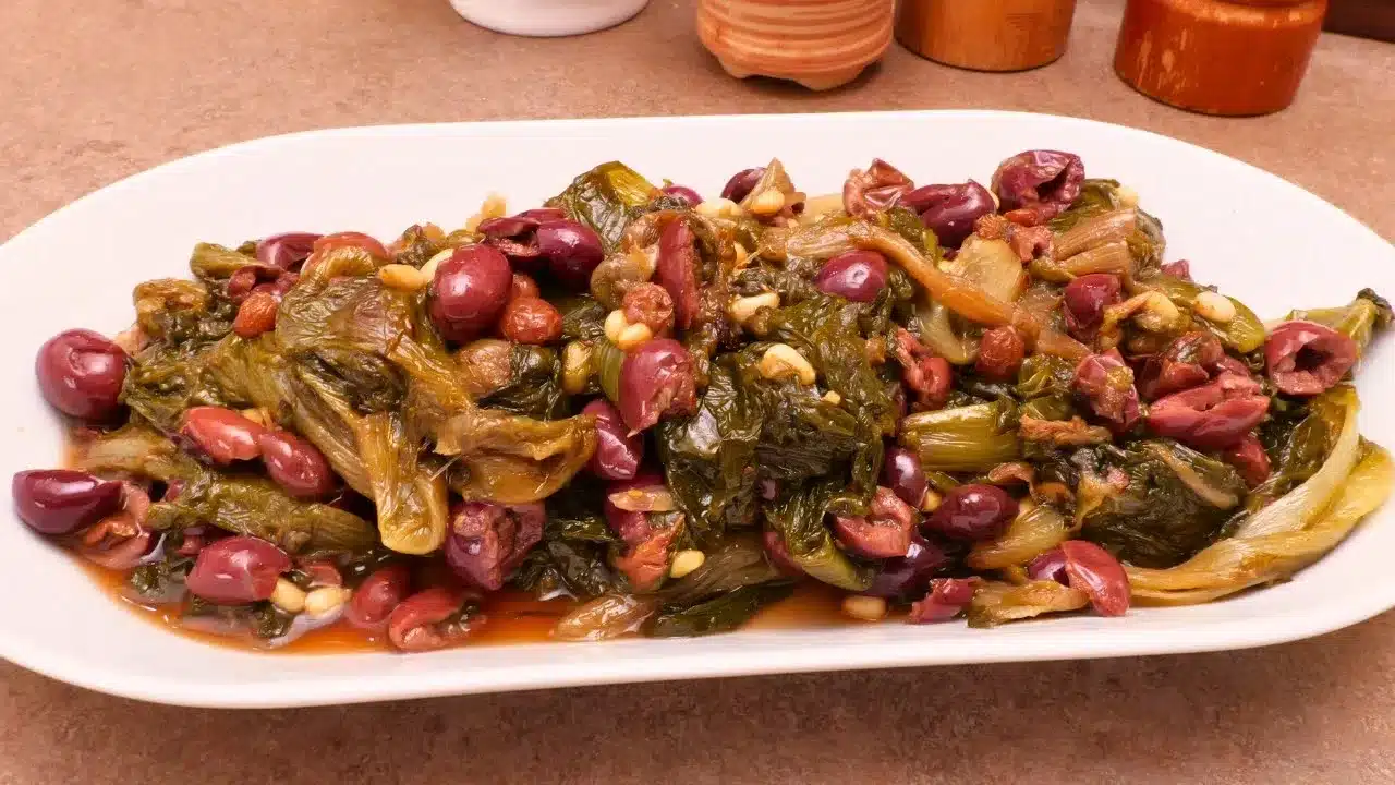 Come preparare la scarola alla napoletana: ricetta tradizionale con olive Itrane, capperi, acciughe, uvetta e pinoli.