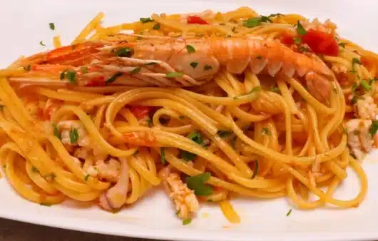Come preparare le linguine scampi e calamari veloci: ricetta facile con pomodorini, vino bianco e prezzemolo.