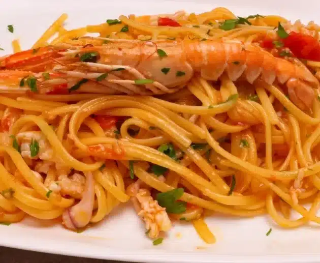 Come preparare le linguine scampi e calamari veloci: ricetta facile con pomodorini, vino bianco e prezzemolo.